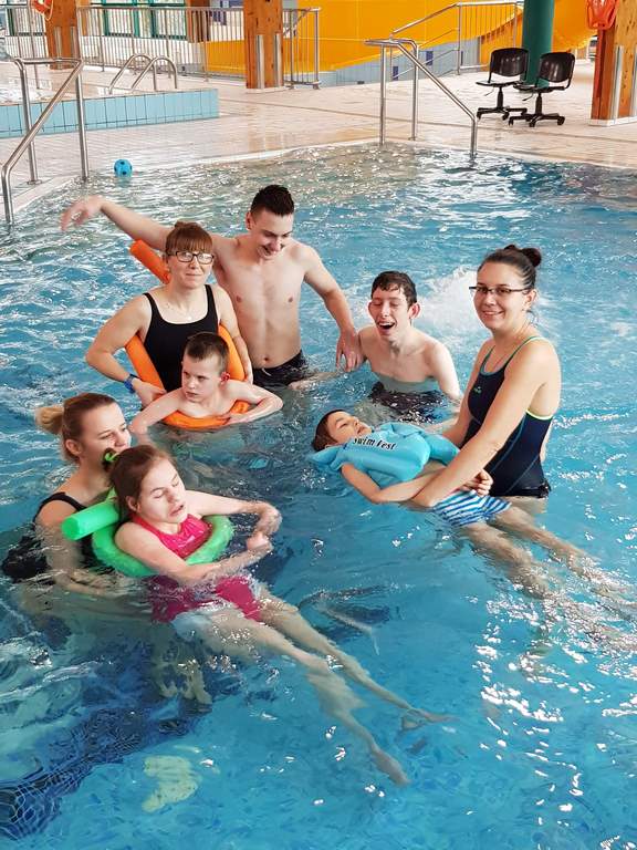 zajęcia na basenie - na zdjęciu grupa dzieci z paniami terapeutkami w basenie z hydromasażem